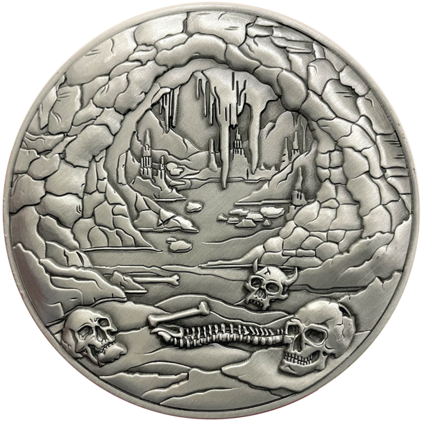 Silver metal coin showing bones and cave entrance