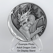 Silver metal coin with dragon on top of plastic display stand