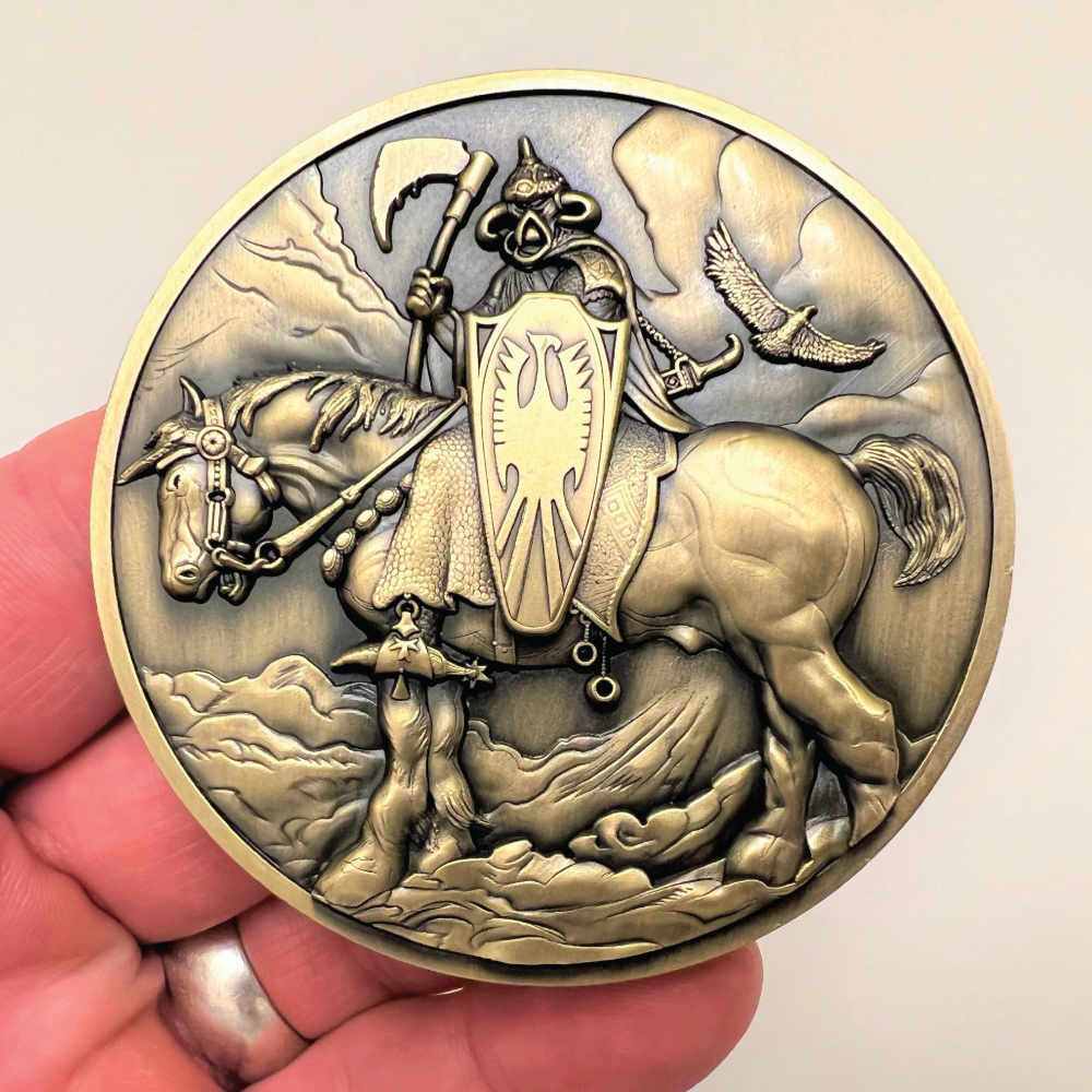 Gold metal coin in hand showing Death Dealer