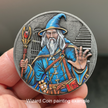 Silver metal coin with painted wizard in blue clothes and white beard